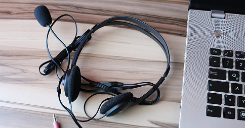 Headset resting next to a Windows-based laptop
