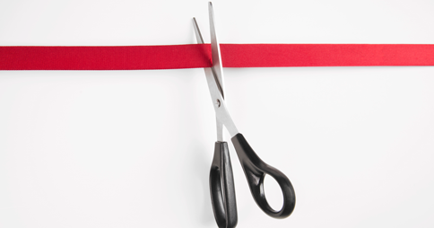 Scissors cutting through red tape
